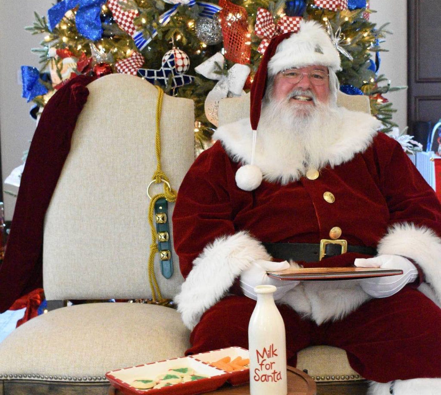 Santa on a couch holding a book with milk bottle